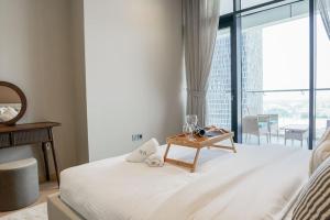 um quarto com uma cama com uma mesa e uma grande janela em AYA Boutique - Cozy 1BR Apartment with Panoramic City Views em Dubai