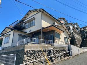 una casa con una pared de roca delante de ella en Nostime lodge 女性限定 female only, en Kitakyushu