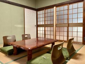 - une salle à manger avec une table et des chaises en bois dans l'établissement Nostime lodge 女性限定 female only, à Kitakyūshū