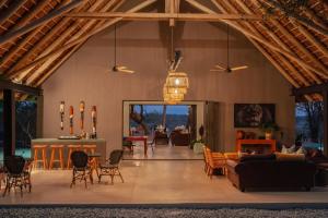 Tomo Safari Lodge في هويدزبروت: غرفة معيشة كبيرة مع سقف مع عوارض خشبية