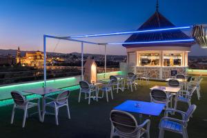 a rooftop patio with tables and chairs at night at Hesperia Córdoba in Córdoba