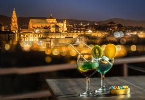 two glasses of wine on a table with a view of a city at Hesperia Córdoba in Córdoba