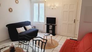 een woonkamer met een blauwe bank en een tv bij Happy Home in Pontault-Combault
