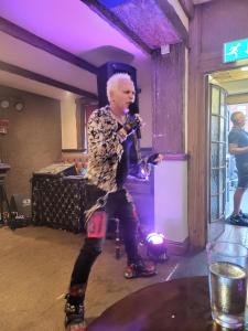 a man standing in a room holding a microphone at The Jolly Sailor in Scalby