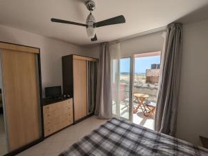 a bedroom with a bed and a ceiling fan at Large Townhouse close to Beach in Sal Rei