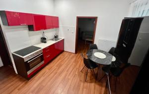 普勒洛夫的住宿－Sušilova 14 apartments IV，一间设有红色橱柜和一张桌子的小厨房