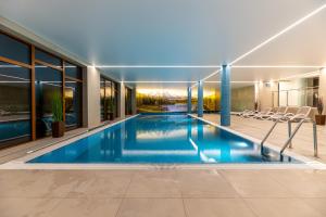 an indoor swimming pool in a house with windows at Apartament Dream View Aspen z Jacuzzi in Szklarska Poręba
