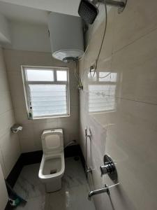 Elle comprend une petite salle de bains pourvue de toilettes et d'une fenêtre. dans l'établissement Pratha Homestay, à Darjeeling