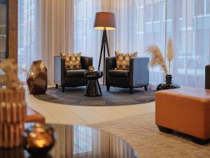 a lobby with two chairs and a table and a lamp at Adina Apartment Hotel Hamburg Michel in Hamburg