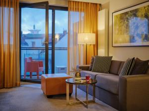 a living room with a couch and a table at Adina Apartment Hotel Hamburg Michel in Hamburg