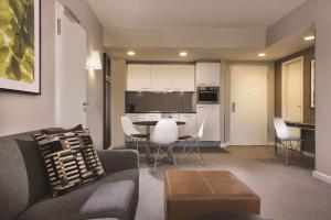 a living room with a couch and a table and chairs at Adina Apartment Hotel Hamburg Michel in Hamburg