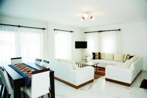 ein Wohnzimmer mit weißen Möbeln und einem Tisch in der Unterkunft Villa Dalyan Emirhan villa Dalyan in Dalyan