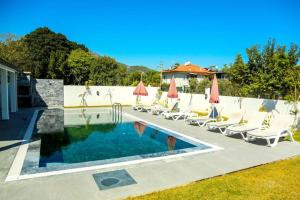 ein Swimmingpool mit Liegestühlen und Sonnenschirmen in der Unterkunft Family- Pool- Bbq- Sleeps 8- Parking- w Air Con in Dalyan