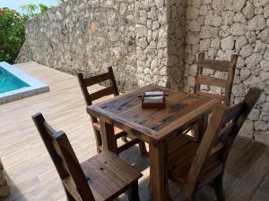 a wooden table and chairs on a deck with a pool at Zi Villa Dhow Beach Cottage in Matemwe