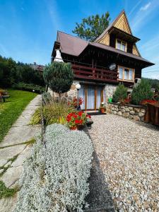 a house with a stone path in front of it at LookTatry Willa Pod Stokiem Apartments & Jacuzzi in Zakopane