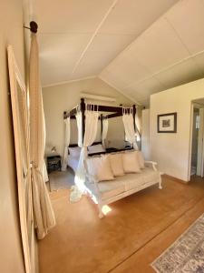 a living room with a white couch and a bed at Out Of Nature Country Lodge in Windhoek