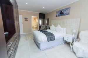 sypialnia z dużym białym łóżkiem i telewizorem w obiekcie Cosy Home In Bluewater Bay w mieście Amsterdamhoek