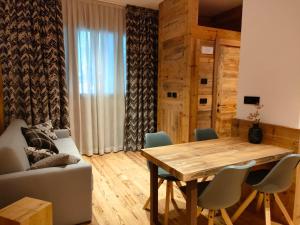 a living room with a wooden table and chairs at Fior di Roccia Apartments- in centro Cervinia, sauna privata, Matterhorn dream in Breuil-Cervinia