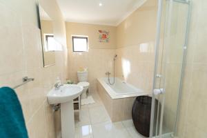 W łazience znajduje się umywalka, prysznic i toaleta. w obiekcie Cosy Home In Bluewater Bay w mieście Amsterdamhoek