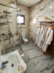 a bathroom with a sink and a shower and a toilet at Hotel Golden Sunset Dakhla in Dakhla