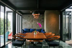 - une salle à manger avec une table et des chaises en bois dans l'établissement MALLO VILLA - DAGO VILLAGE - NEW VILLA & FURNISH, à Bandung