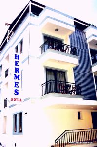 a white building with balconies and a hotel at Hotel Hermes in Kaş