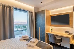 una camera d'albergo con letto, scrivania e finestra di CITY HILL Luxury Apartments a Ioannina