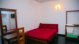 Bird View Resort Anawilundawa : غرفة صغيرة بسرير احمر ومرآة