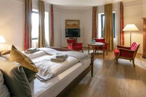 ein Hotelzimmer mit einem großen Bett, einem Tisch und Stühlen in der Unterkunft Schlosshotel Braunfels in Braunfels