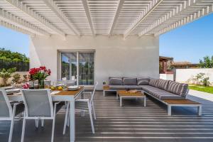 a patio with a couch and a table and chairs at Villa DellaTerra in Alcamo
