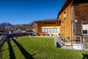 a house with a yard next to a building at Simons Herberge in Meiringen