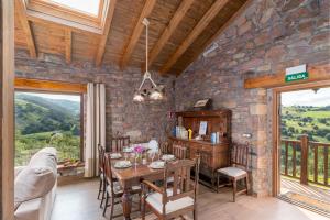 a dining room with a table and a stone wall at Leyendas del Miera in Liérganes