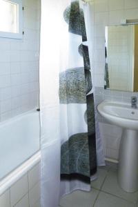 La salle de bains est pourvue d'un rideau de douche et d'un lavabo. dans l'établissement Holiday home, Beg Meil, à Fouesnant