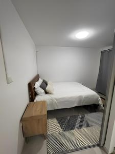Dormitorio pequeño con cama y mesa en CHILL HOME- T2 Aménagé, en Sainte-Suzanne