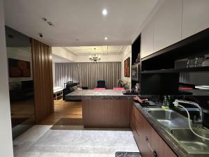 a kitchen with a sink and a living room at Klcc studio with a rooftop garden playground in Kuala Lumpur
