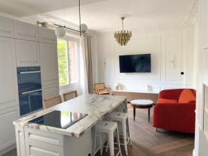 uma cozinha e sala de estar com um sofá vermelho em Le petit Versailles - T2 au centre-ville em Grenoble