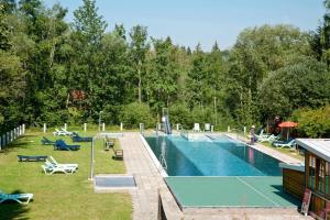 uma piscina com cadeiras e um resort em Feriendorf Reichenbach - Biberweg 12 em Nesselwang