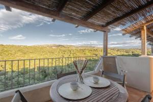 einen Tisch und Stühle auf einem Balkon mit Aussicht in der Unterkunft Elegant Residence Ea Bianca noi0606nm in Cala Bitta