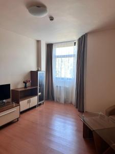 a living room with a television and a large window at Flora Apartment 423 in Borovets