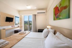 a hotel room with a bed and a tv at Atrion Resort Hotel in Agia Marina Nea Kydonias