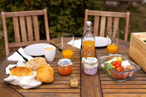 una mesa de madera con comida y vasos de zumo de naranja en Gesztenyés Ház, en Nagymaros