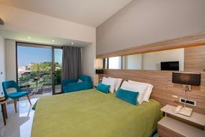 a hotel room with a green bed and a balcony at Atrion Resort Hotel in Agia Marina Nea Kydonias