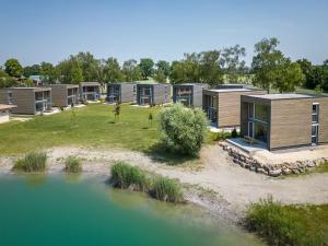 a row of modular homes next to a body of water at Feriendorf am Sonnensee in Leipheim