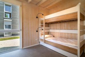 a bedroom with bunk beds and a window at Feriendorf am Sonnensee in Leipheim