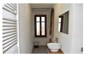 W łazience znajduje się biała umywalka i lustro. w obiekcie Ca' Ronzini w mieście Castiglione Falletto