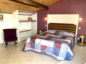 ein Schlafzimmer mit einem Bett und einem Stuhl in der Unterkunft La Halte de Segondignac in Saint-Germain-dʼEsteuil