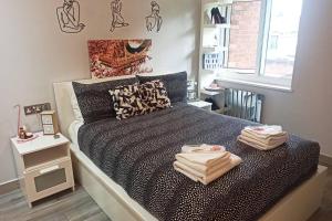 um quarto com uma cama com toalhas em Madison - Cozy one-bedroom flat em Eltham