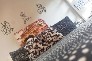 uma cama com duas almofadas e uma imagem de uma lareira em Madison - Cozy one-bedroom flat em Eltham