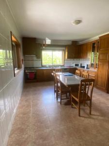 a kitchen with a table and chairs in a room at Casa do Senhor da Ponte in Gondifelos