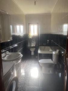 a bathroom with two sinks and a toilet and a tub at Casa do Senhor da Ponte in Gondifelos